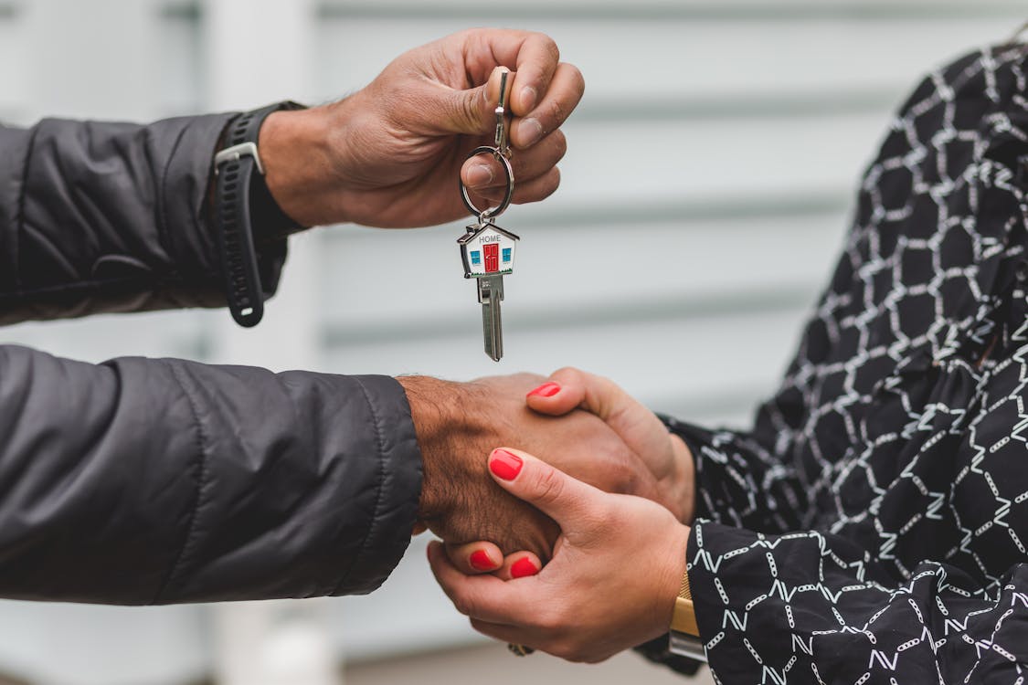 A smartly dressed real estate professional with a tablet inspects the exterior of a modern architectural building, representing diverse career paths beyond residential sales.