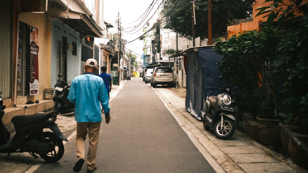 A woman walks down a quiet, charming residential street with picturesque homes, representing the experience of living in a local neighborhood.